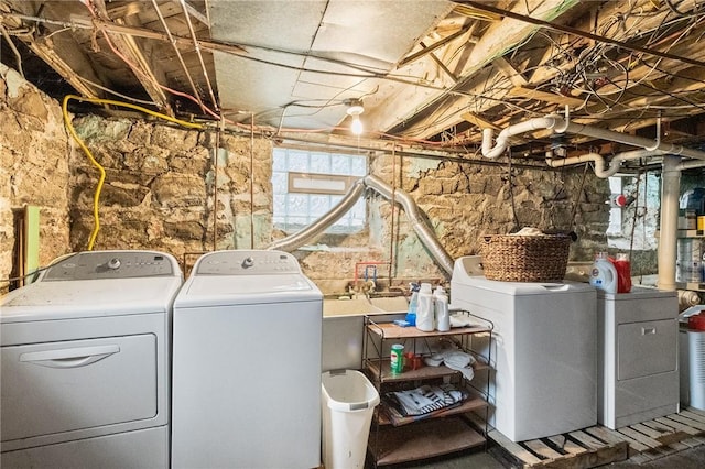 clothes washing area with washing machine and clothes dryer and laundry area