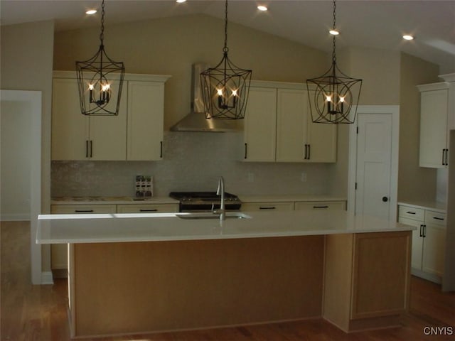 kitchen with an island with sink, light countertops, wall chimney exhaust hood, and a sink