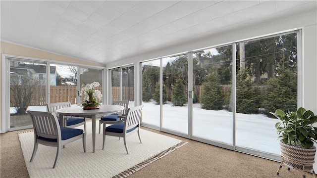 sunroom / solarium featuring plenty of natural light and vaulted ceiling