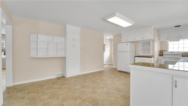 kitchen with visible vents, white appliances, baseboards, and white cabinetry