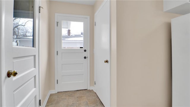 doorway to outside featuring stone finish floor and baseboards