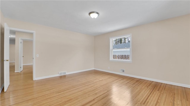 unfurnished room featuring light wood-style flooring, baseboards, and visible vents