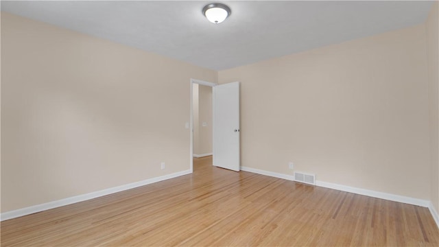 spare room featuring visible vents, light wood-style flooring, and baseboards