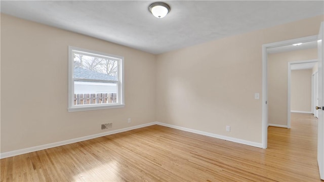 spare room with visible vents, light wood-style flooring, and baseboards