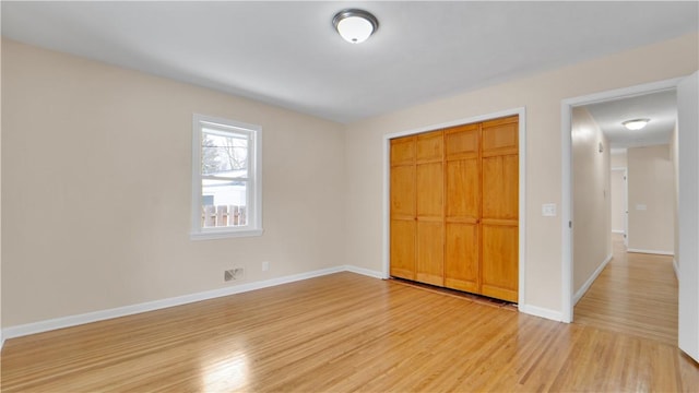 unfurnished bedroom featuring a closet, visible vents, light wood-type flooring, and baseboards