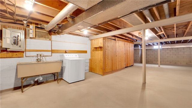 unfinished basement with electric panel, washer / dryer, and a sink