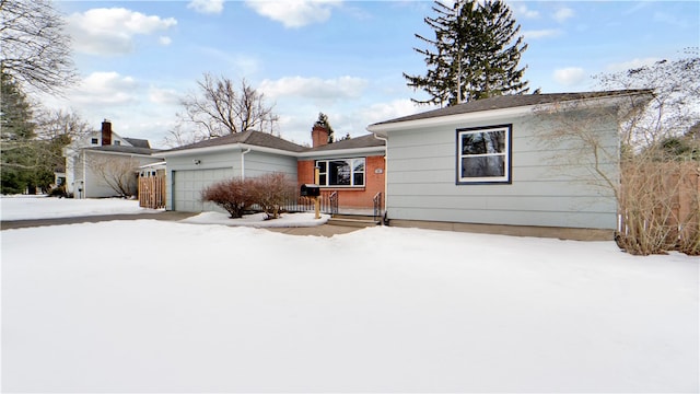 single story home with brick siding, a chimney, and a garage