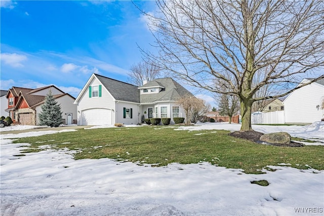 view of front of house with a garage, a lawn, and fence