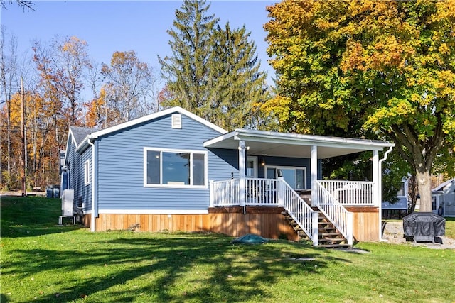 manufactured / mobile home featuring a front yard, stairway, and a porch