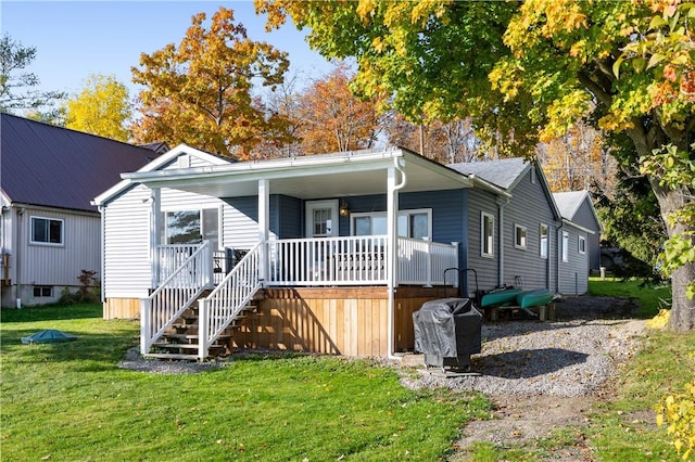 view of front of property featuring a porch, stairs, and a front lawn