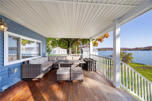 wooden deck featuring an outdoor living space and a water view