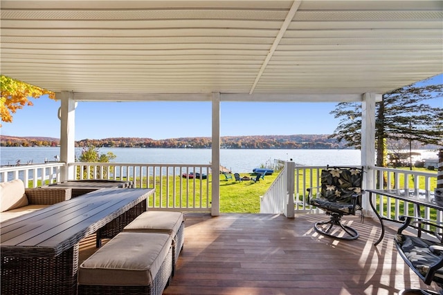 wooden terrace featuring a yard and a water view