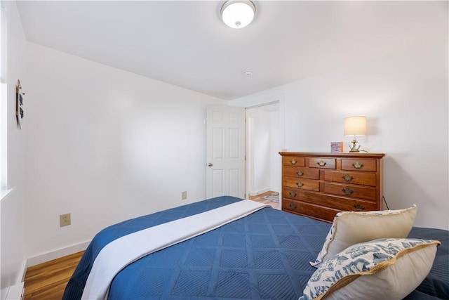 bedroom with baseboards and wood finished floors