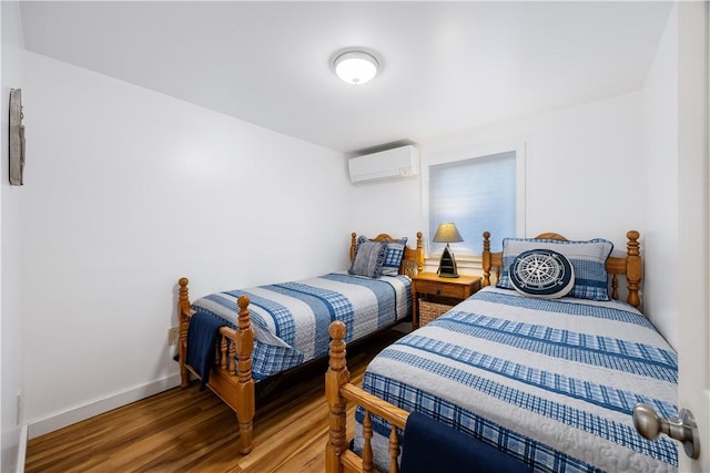 bedroom with light wood-type flooring, a wall mounted AC, and baseboards