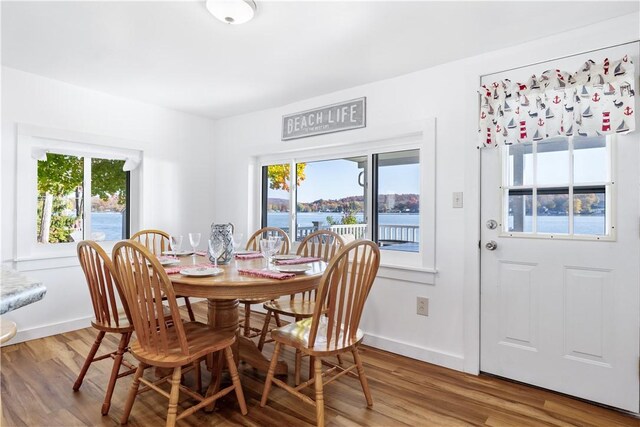 dining area with plenty of natural light, baseboards, and wood finished floors