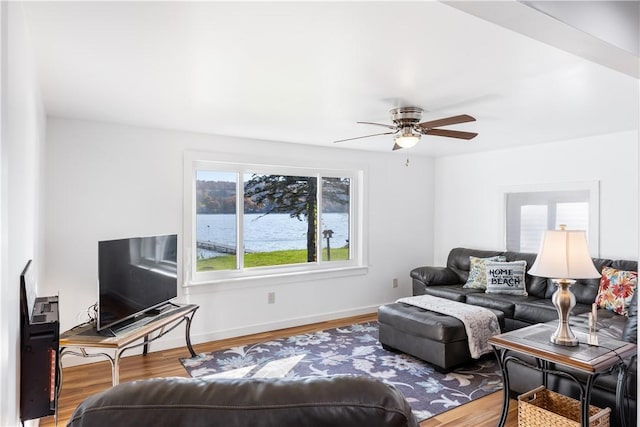 living area with a ceiling fan, wood finished floors, and baseboards