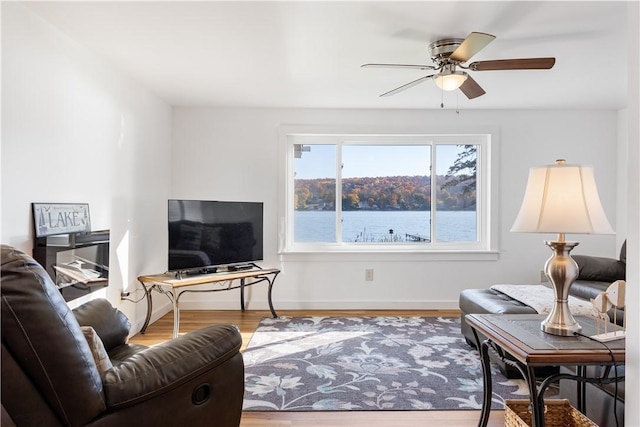 living area with ceiling fan, baseboards, and wood finished floors