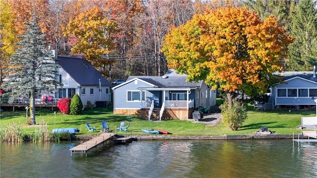 rear view of house featuring a yard and a deck with water view