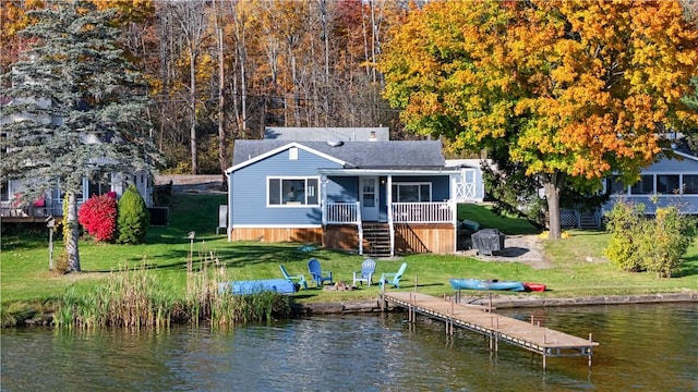 back of house with stairs, a yard, a water view, and roof with shingles