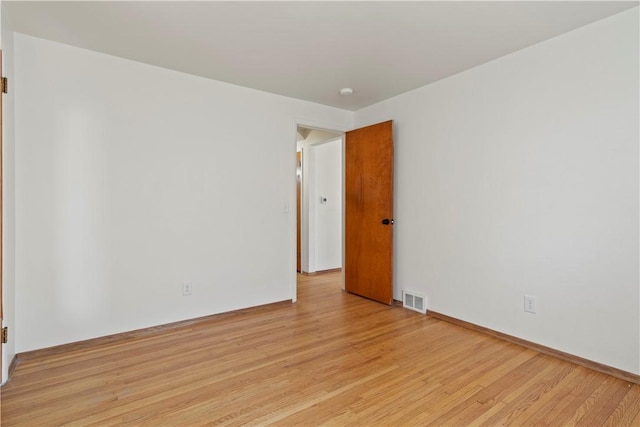 unfurnished room featuring light wood-style floors and visible vents