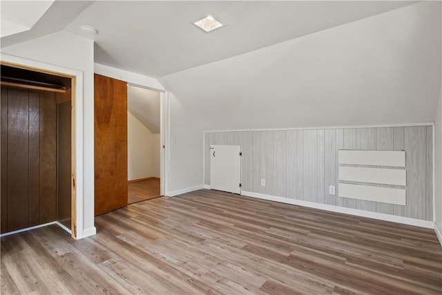 additional living space with vaulted ceiling and wood finished floors