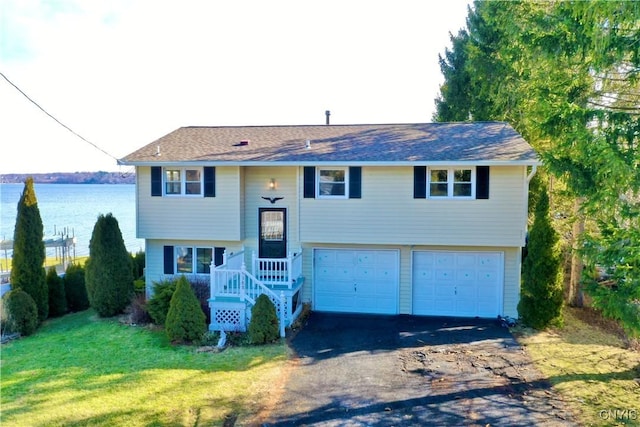 bi-level home with aphalt driveway, an attached garage, and a front lawn