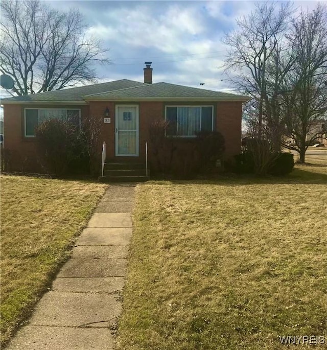 view of front of house with a chimney and a front lawn