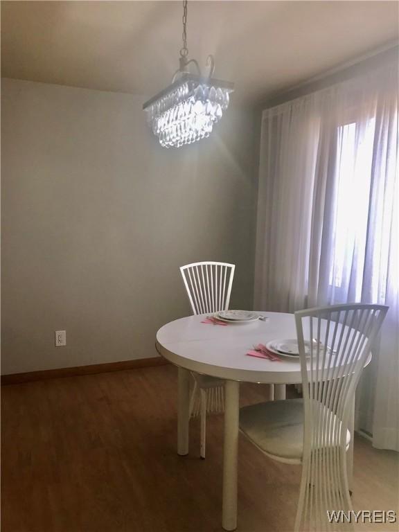 dining room featuring an inviting chandelier, light wood-style floors, and baseboards