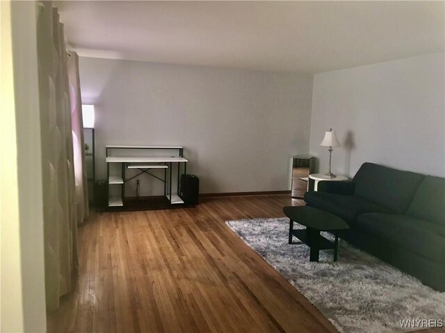 living room with baseboards and wood finished floors