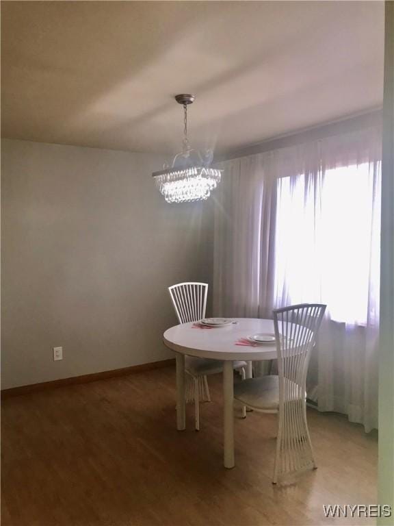 dining room with light wood-style flooring, baseboards, and a chandelier