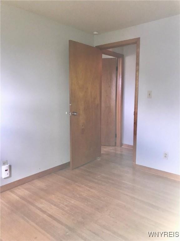 unfurnished room with light wood-style floors and baseboards