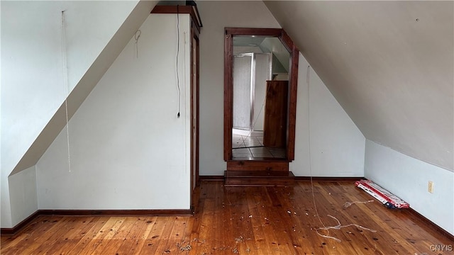 bonus room featuring vaulted ceiling, baseboards, and hardwood / wood-style floors