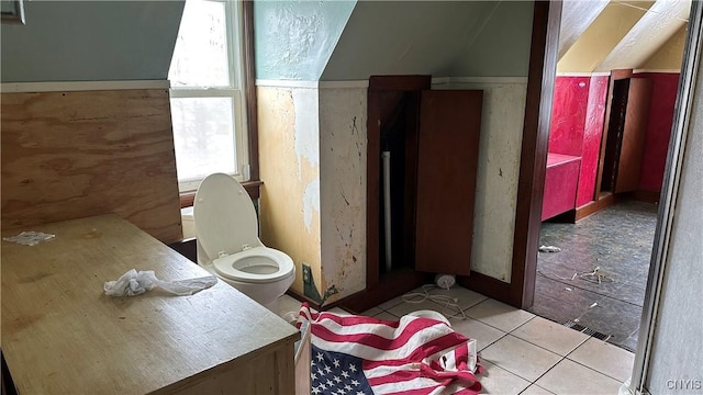 bathroom with tile patterned floors, toilet, and vaulted ceiling