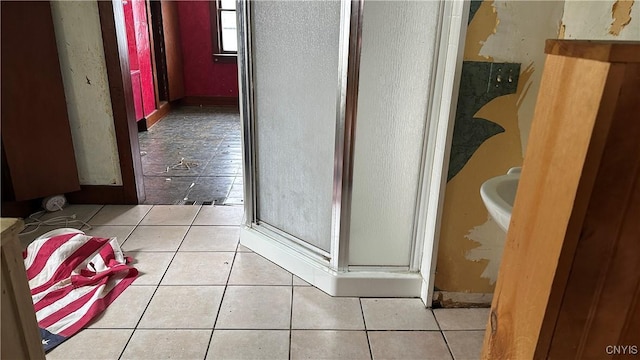 bathroom with a shower with shower door and tile patterned flooring