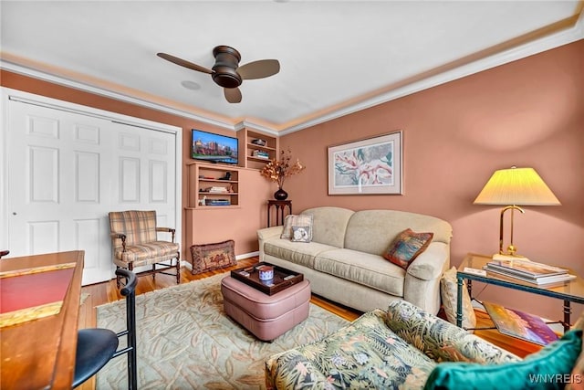 living area with ceiling fan, wood finished floors, and crown molding