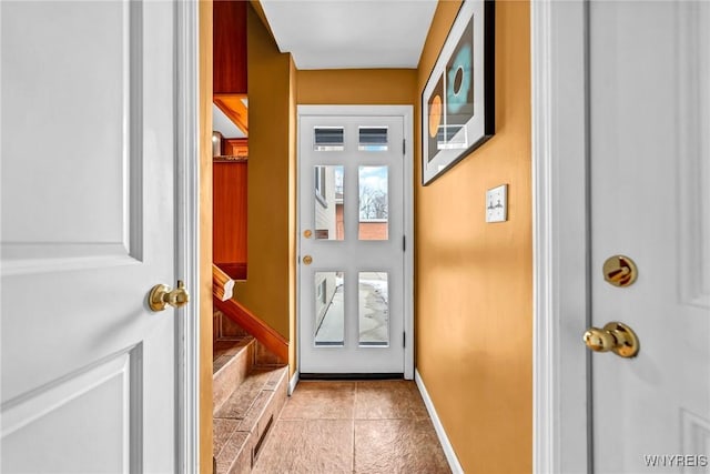 entryway with light tile patterned floors, stairway, and baseboards