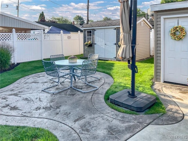 view of patio / terrace with a storage unit, outdoor dining area, an outdoor structure, and fence