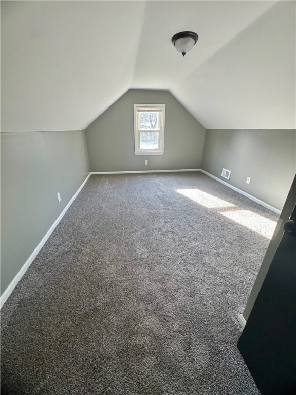 additional living space with lofted ceiling, carpet, baseboards, and visible vents