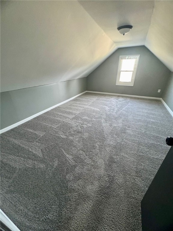 bonus room with vaulted ceiling, carpet flooring, and baseboards