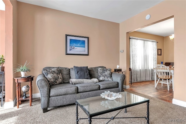 carpeted living room featuring baseboards