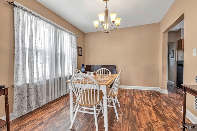 dining space with a chandelier, baseboards, and wood finished floors