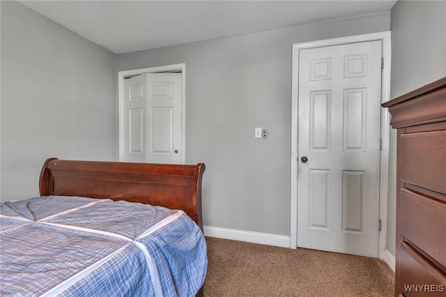 carpeted bedroom featuring baseboards and a closet