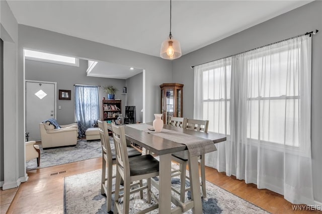 dining area with visible vents and light wood-style flooring