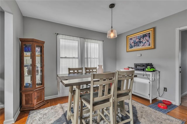 dining space featuring wood finished floors and baseboards