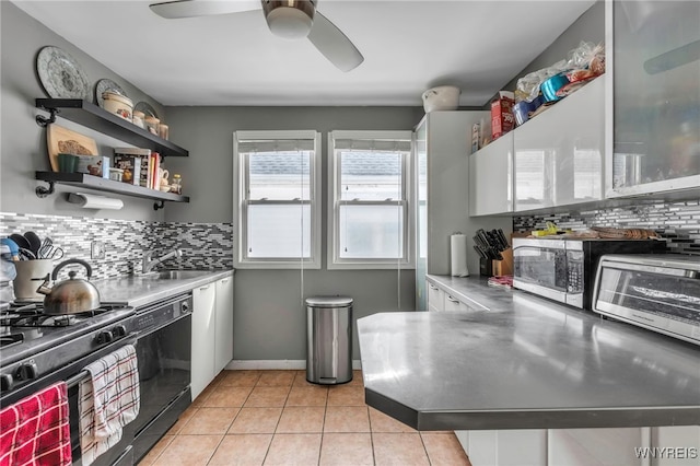 kitchen featuring stainless steel counters, range with gas stovetop, light tile patterned floors, decorative backsplash, and dishwasher