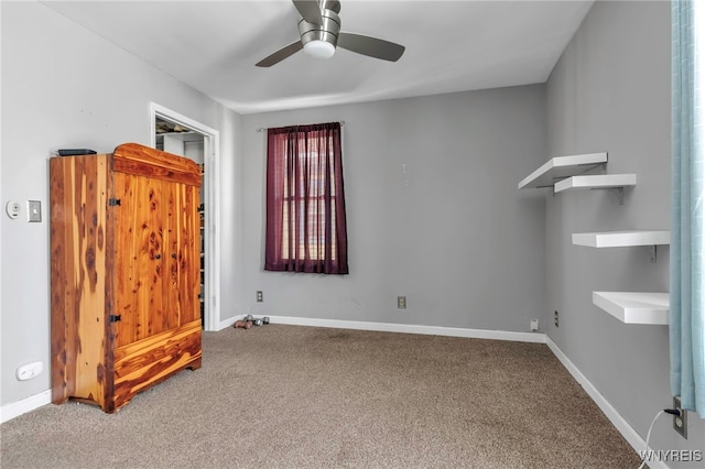 carpeted empty room featuring baseboards and a ceiling fan