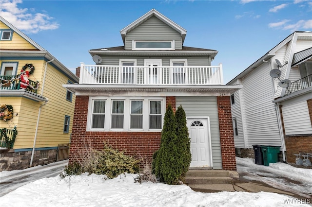 american foursquare style home featuring a balcony and brick siding