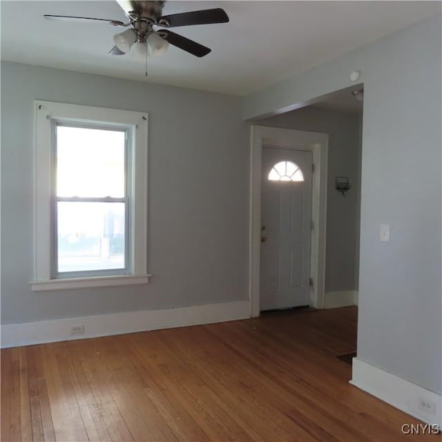 foyer entrance with hardwood / wood-style flooring, baseboards, and ceiling fan