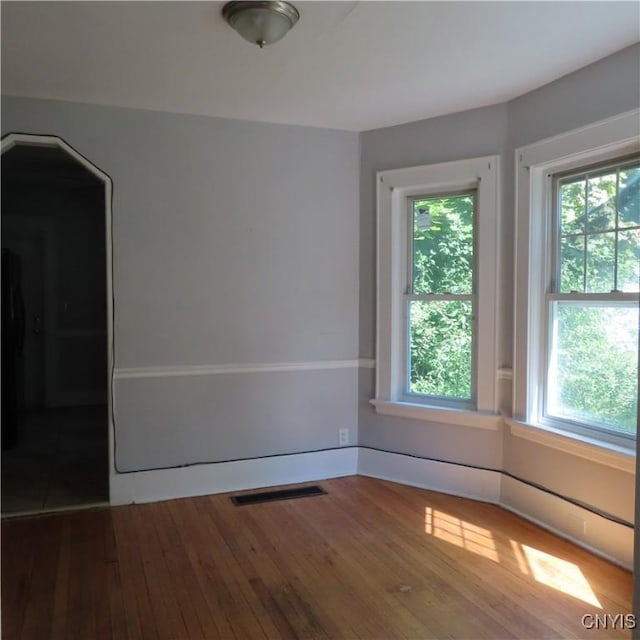 unfurnished room featuring visible vents and hardwood / wood-style floors