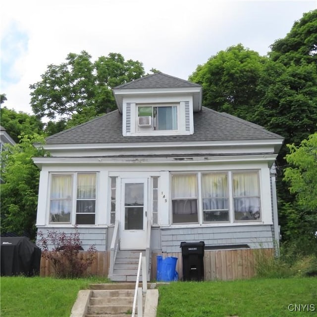 bungalow with entry steps and a shingled roof